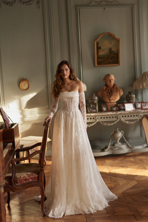 Lace wedding dress with corset, off-the-shoulder straps, and train indoors